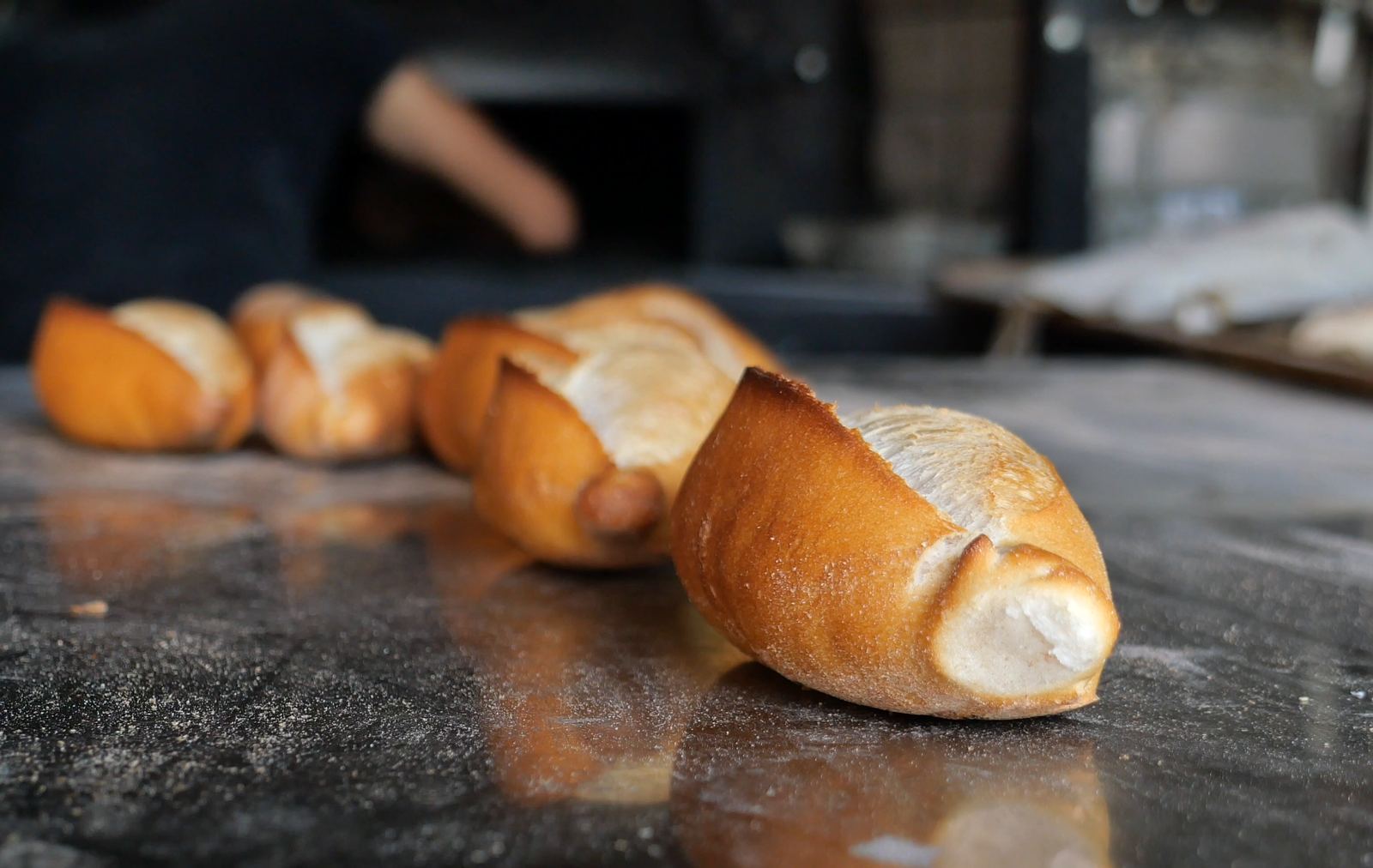 Pães franceses sobre o balcão de uma padaria.